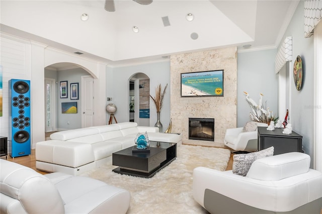 137 Big Pass Ln, Sarasota, FL 34242 - living area with a premium fireplace, ornamental molding, ceiling fan, arched walkways, and a tray ceiling