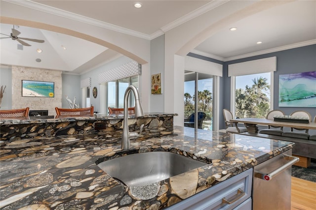 137 Big Pass Ln, Sarasota, FL 34242 - kitchen with dark stone countertops, light wood-style flooring, a sink, and open floor plan