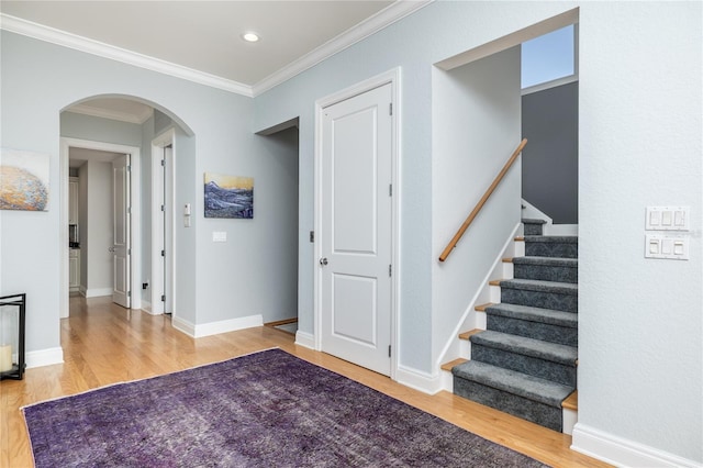 137 Big Pass Ln, Sarasota, FL 34242 - interior space with crown molding, stairway, baseboards, arched walkways, and wood finished floors