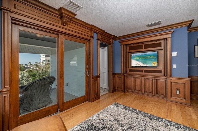137 Big Pass Ln, Sarasota, FL 34242 - interior space with ornamental molding, a textured ceiling, light wood-style floors, and visible vents