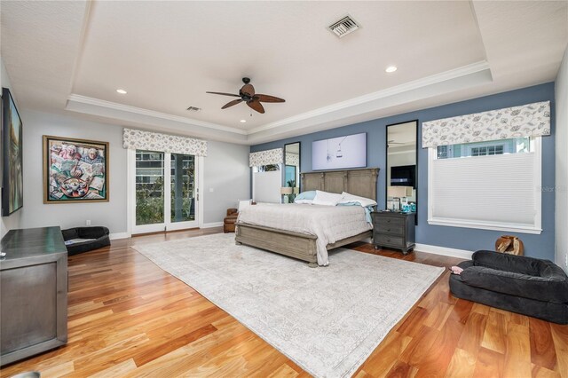 137 Big Pass Ln, Sarasota, FL 34242 - bedroom with baseboards, light wood-type flooring, visible vents, and a raised ceiling