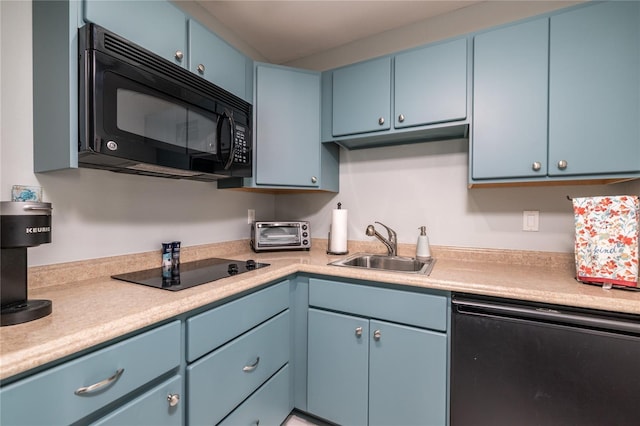 137 Big Pass Ln, Sarasota, FL 34242 - kitchen with blue cabinetry, light countertops, a sink, and black appliances