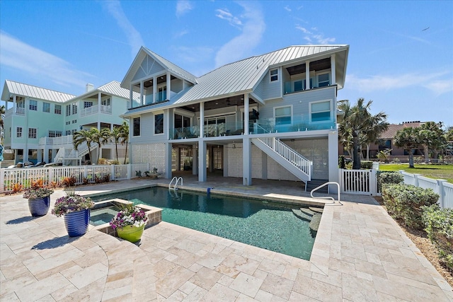 137 Big Pass Ln, Sarasota, FL 34242 - rear view of house with metal roof, fence, a patio, a standing seam roof, and an in ground hot tub