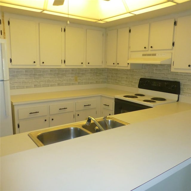 kitchen featuring backsplash, under cabinet range hood, light countertops, electric stove, and freestanding refrigerator