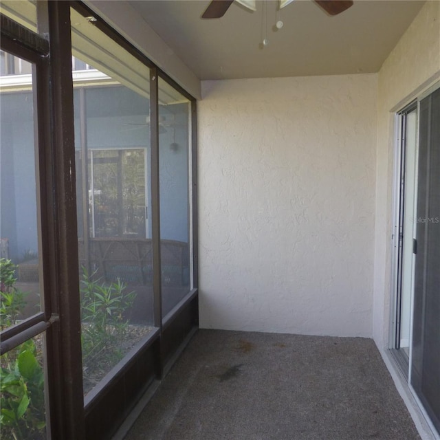 unfurnished sunroom with ceiling fan