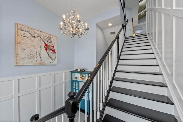 stairs with a wainscoted wall, visible vents, recessed lighting, a decorative wall, and a chandelier