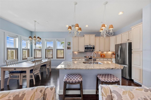 kitchen featuring a sink, a notable chandelier, appliances with stainless steel finishes, and cream cabinets