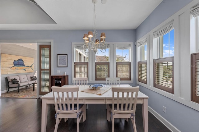 dining area with an inviting chandelier, baseboards, and dark wood-style flooring