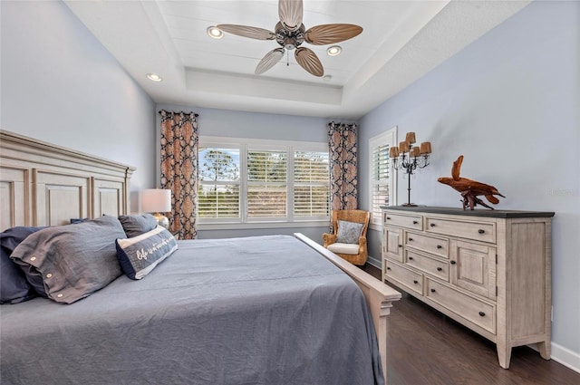 bedroom with a ceiling fan, dark wood-style floors, baseboards, recessed lighting, and a raised ceiling