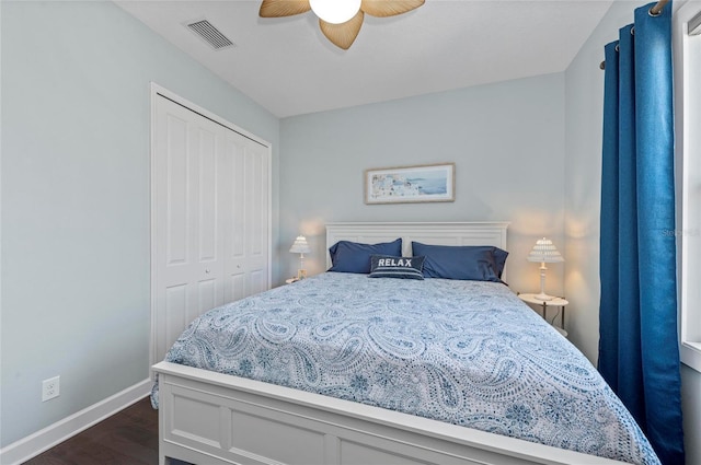 bedroom featuring visible vents, dark wood-type flooring, baseboards, a closet, and a ceiling fan