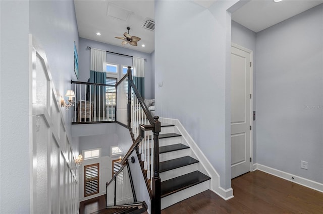 stairway with wood finished floors, visible vents, baseboards, a high ceiling, and recessed lighting