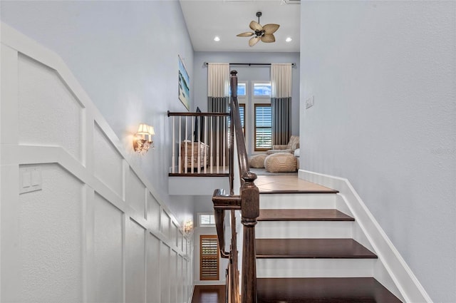 stairway with recessed lighting, baseboards, and a high ceiling