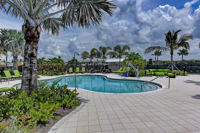 community pool with a patio and fence