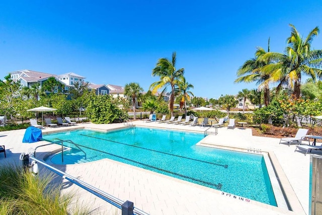 pool with a patio and fence