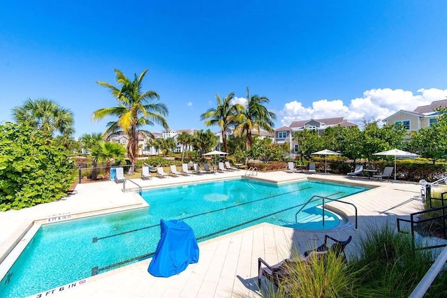 community pool with a patio area and fence