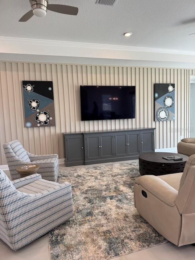 living area featuring a textured ceiling, crown molding, and ceiling fan