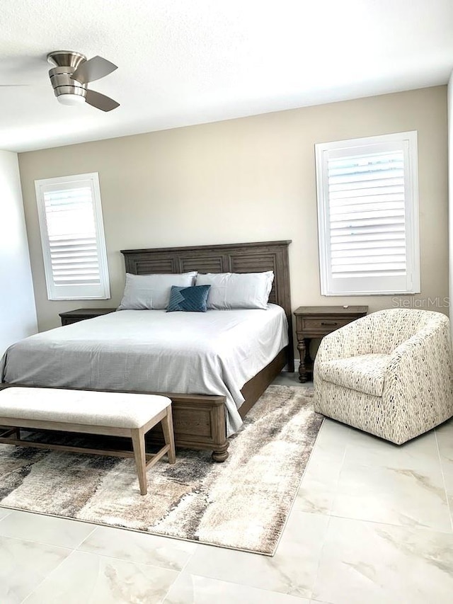 bedroom featuring a ceiling fan and marble finish floor