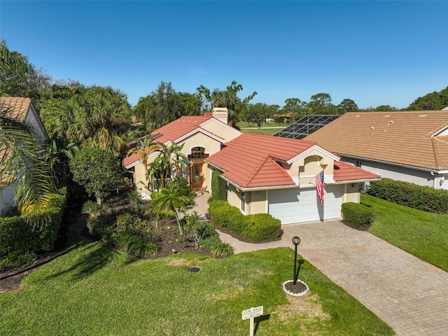 view of front of home with driveway, a front lawn, an attached garage, a lanai, and a tiled roof