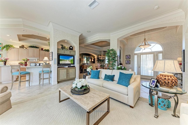 living area featuring arched walkways, light tile patterned floors, crown molding, and visible vents