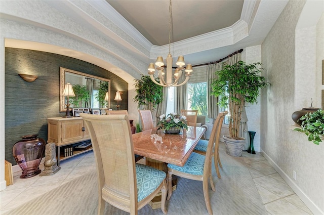 dining area with baseboards, ornamental molding, light tile patterned floors, an inviting chandelier, and a raised ceiling