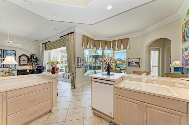 kitchen featuring light brown cabinets, ornamental molding, white dishwasher, light tile patterned flooring, and a sink