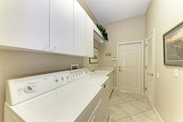 clothes washing area featuring a sink, cabinet space, light tile patterned floors, and washer and clothes dryer