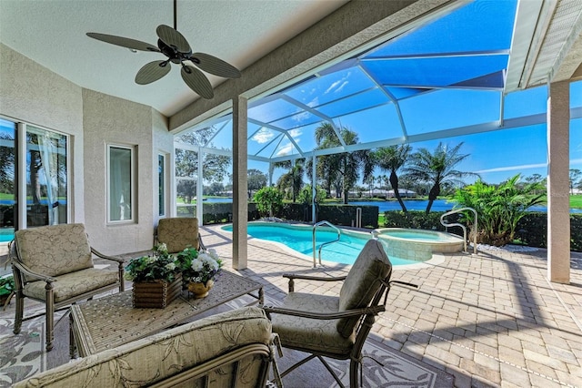 view of pool with a pool with connected hot tub, a lanai, a ceiling fan, and a patio area