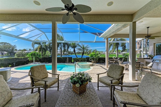 view of swimming pool featuring a patio area, glass enclosure, a pool with connected hot tub, and ceiling fan