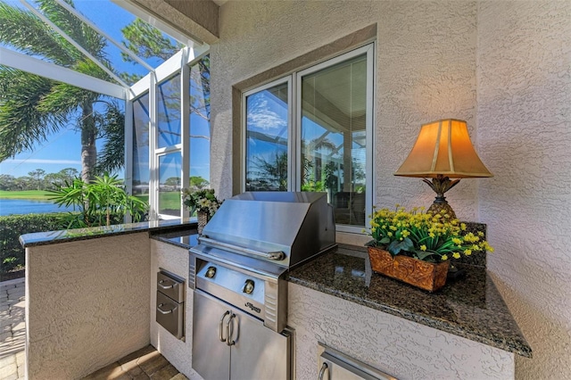 exterior space with a water view, an outdoor kitchen, a lanai, and a grill