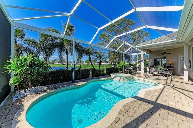 view of swimming pool featuring glass enclosure, a patio area, a pool with connected hot tub, and ceiling fan