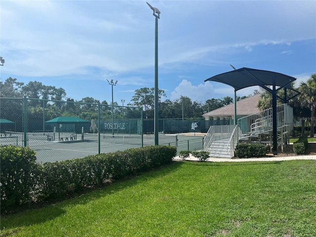 view of sport court featuring a yard and fence