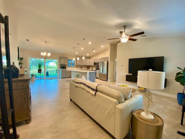 living room featuring visible vents, ceiling fan with notable chandelier, baseboards, and vaulted ceiling