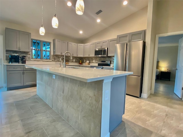 kitchen with visible vents, lofted ceiling, a sink, gray cabinetry, and stainless steel appliances