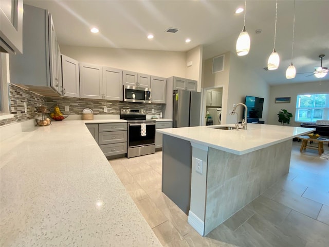 kitchen featuring visible vents, gray cabinets, appliances with stainless steel finishes, light countertops, and vaulted ceiling