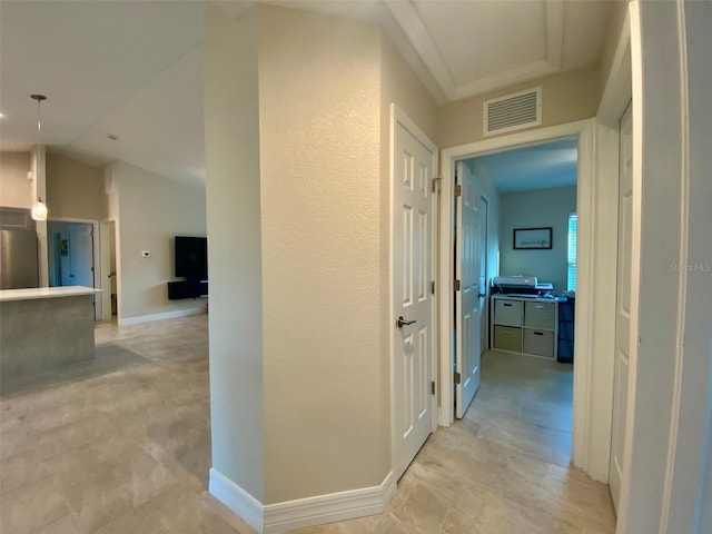 corridor with visible vents, lofted ceiling, and baseboards