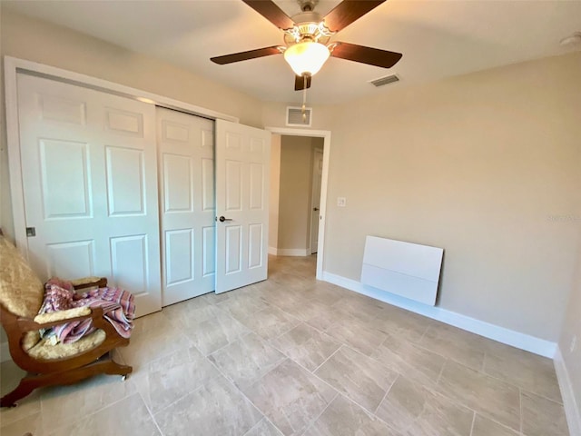 unfurnished bedroom featuring a ceiling fan, baseboards, visible vents, and a closet