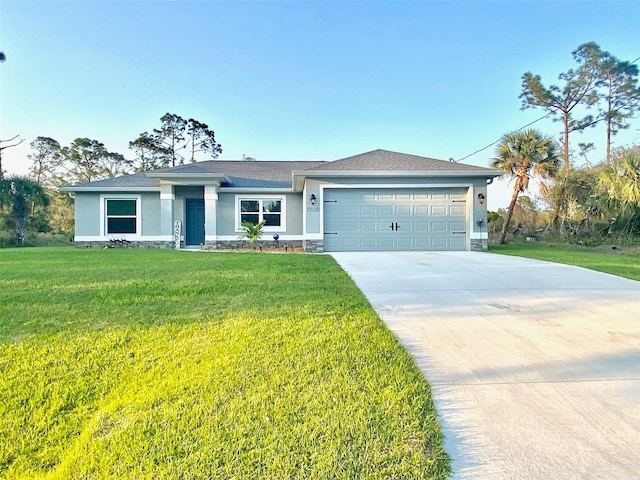 view of front of home with a front yard, an attached garage, driveway, and stucco siding