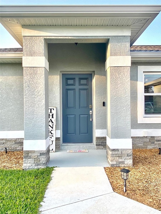 view of exterior entry featuring stucco siding