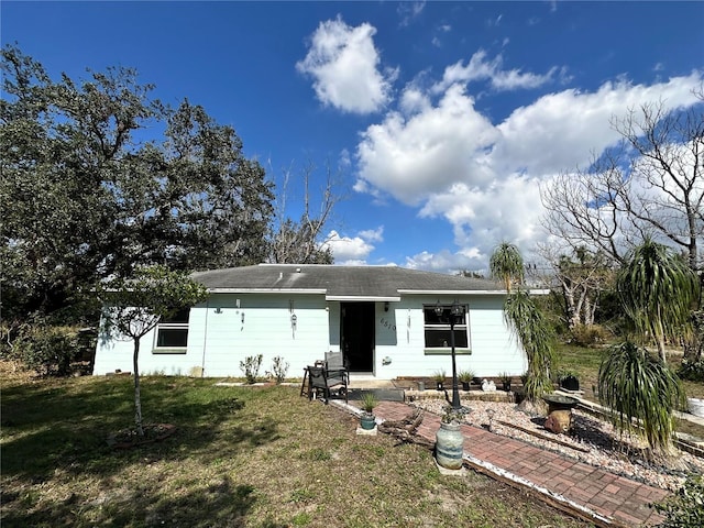 rear view of house featuring a lawn