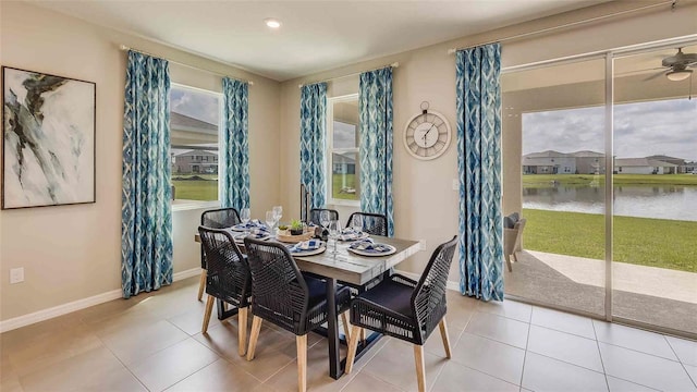 tiled dining area featuring a water view, baseboards, recessed lighting, and a ceiling fan