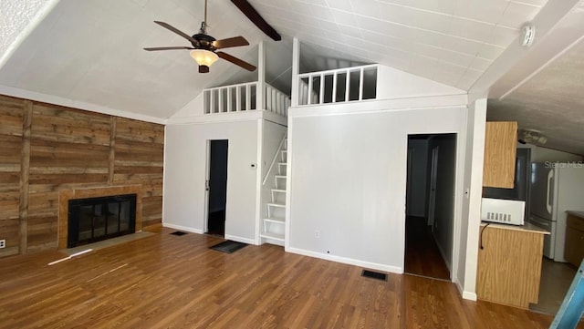 unfurnished living room with visible vents, ceiling fan, a fireplace with flush hearth, stairs, and wood finished floors