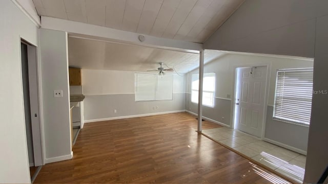 spare room featuring wood finished floors, baseboards, vaulted ceiling with beams, ceiling fan, and wood ceiling