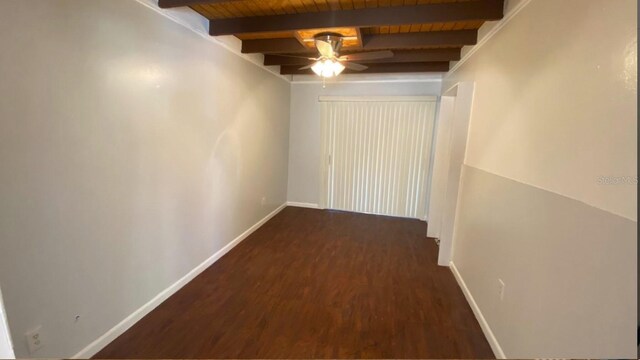 interior space featuring wooden ceiling, dark wood-style floors, baseboards, and beam ceiling