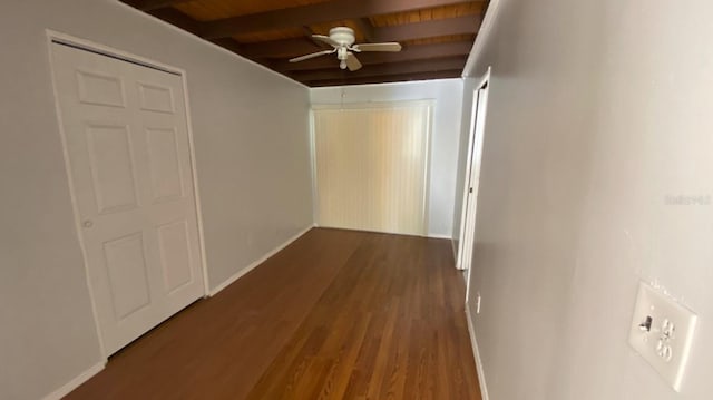 hallway featuring baseboards, beam ceiling, wood ceiling, and wood finished floors