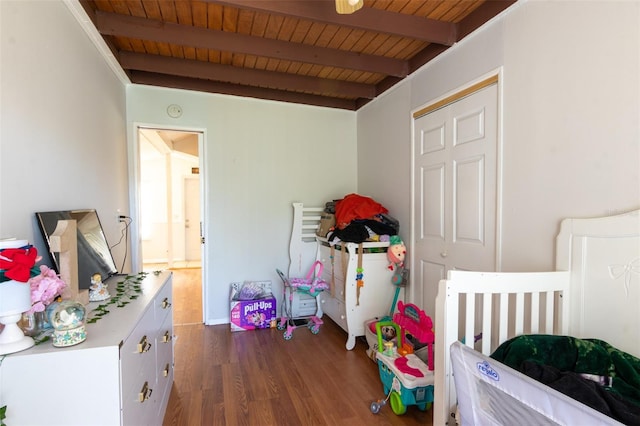 bedroom featuring beam ceiling, wood ceiling, and wood finished floors