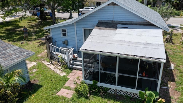 exterior space with a lawn, a deck, and a sunroom