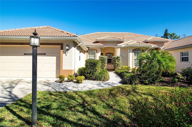 mediterranean / spanish-style home with stucco siding, concrete driveway, a front lawn, a garage, and a tile roof