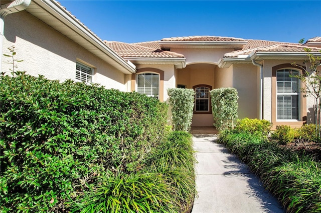 property entrance featuring stucco siding and a tiled roof