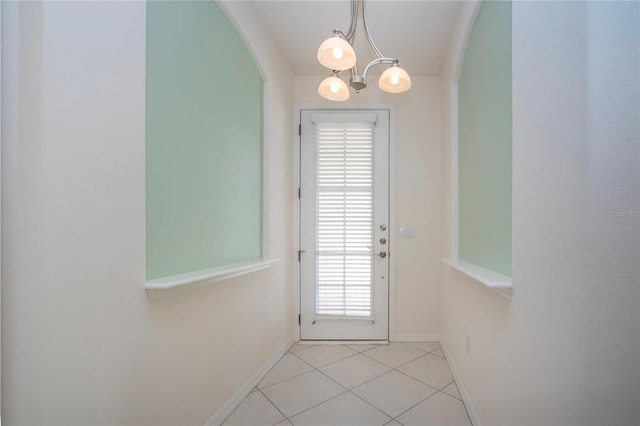 entryway featuring light tile patterned floors, baseboards, and a chandelier