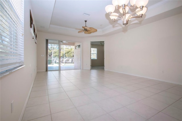 spare room featuring a raised ceiling, ornamental molding, ceiling fan with notable chandelier, light tile patterned floors, and baseboards